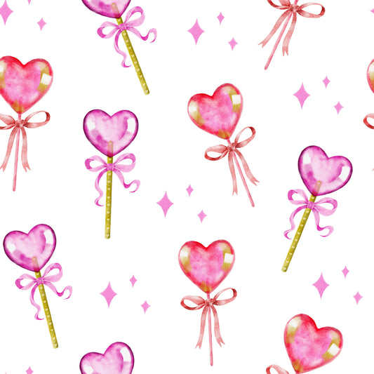 Pattern of pink heart-shaped lollipops with bows on a white background